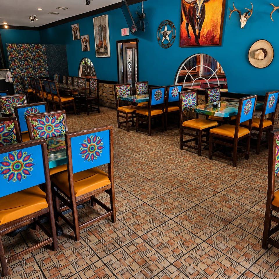 Vibrant restaurant interior with blue walls, colorful chairs, and Southwestern decor.
